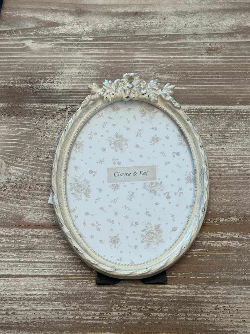 Cornice ovale bianca con decorazione a fiocco