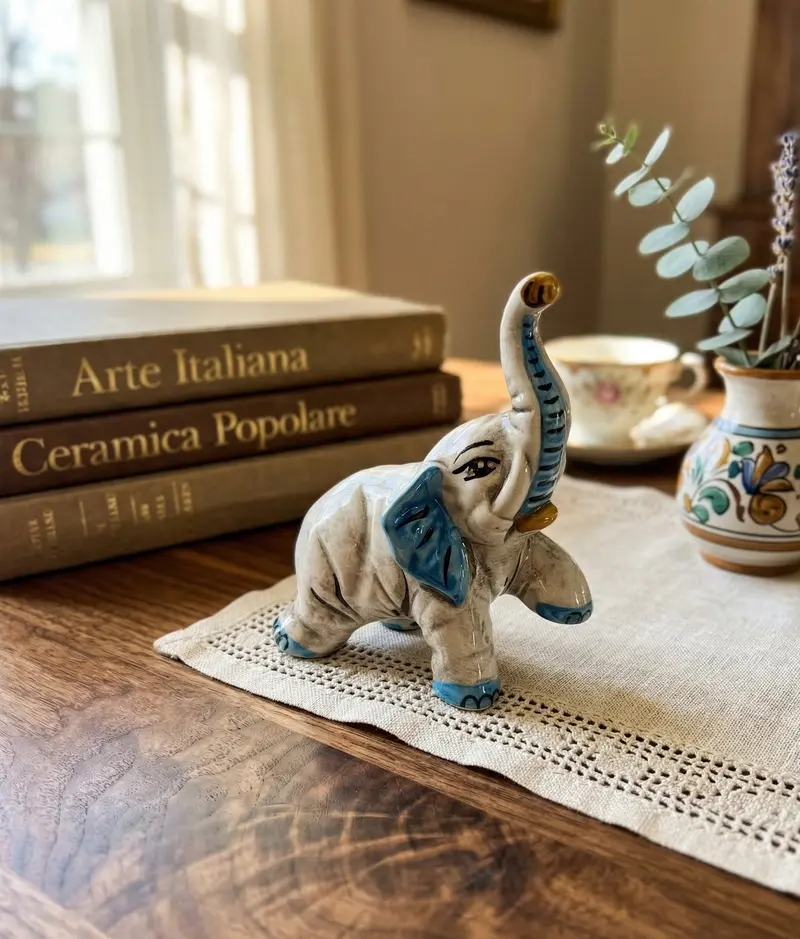 Elefante in ceramica di Caltagione realizzato a mano, animali portafortuna art. piede su azzurro